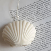 Shell-shaped candle on a book